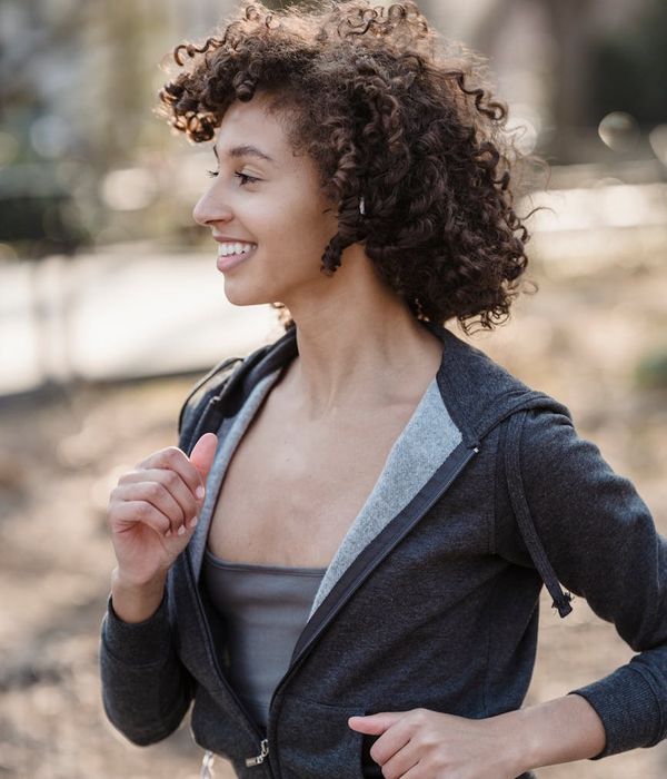 Woman feeling energetic and happy outdoors in the morning sun.